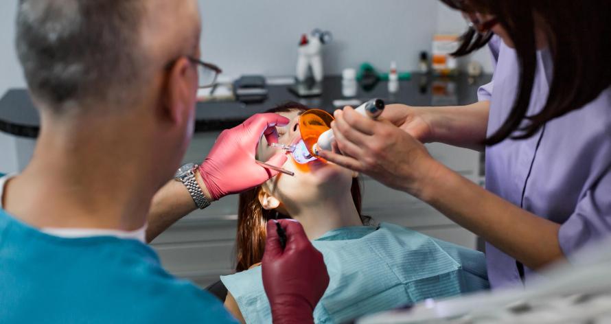 Young female patient takes a dental attendance in the dentist's office.