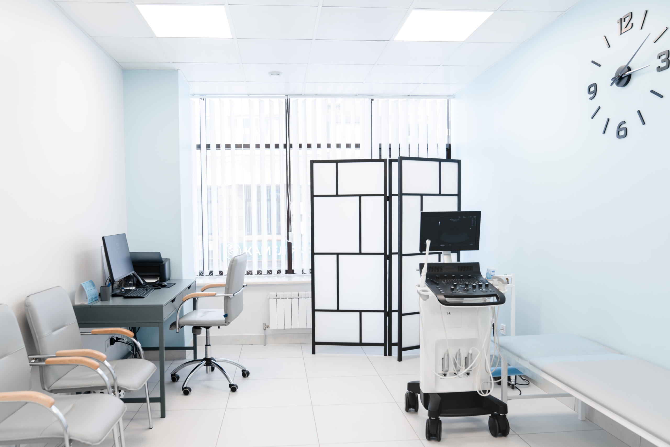 Interior of hospital room with ultrasound machine. A white and sterile medical cabinet with advanced ultrasound technology. Gynecologist's chair and ultrasound machine in a gynecologist clinic
